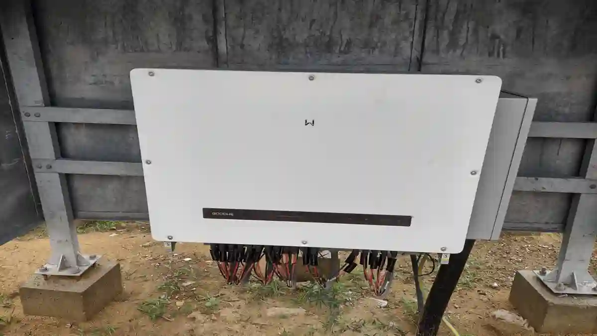 Commercial solar grid installation showing multiple solar panels connected to a string inverter for AC power conversion